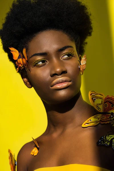 Attrayant afro-américain jeune femme avec des papillons sur jaune — Photo de stock