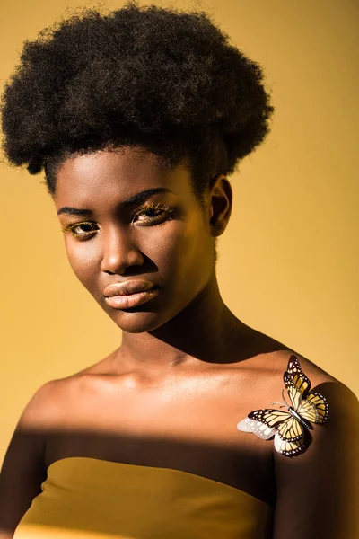 Belle femme afro-américaine avec des papillons regardant caméra avec brun — Photo de stock