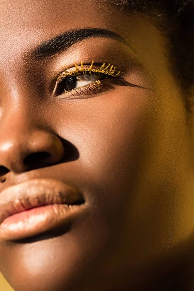 Abgeschnittene Ansicht der schönen afrikanisch-amerikanischen Frau mit gelben Wimpern, die wegschaut — Stockfoto