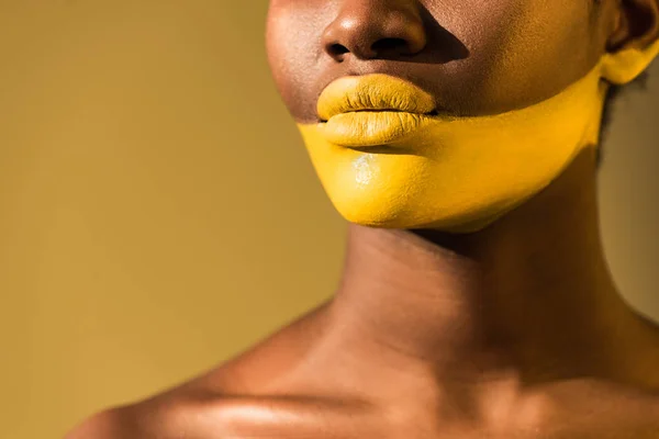 Vista cortada da mulher americana africana com arte corporal amarela em marrom — Fotografia de Stock