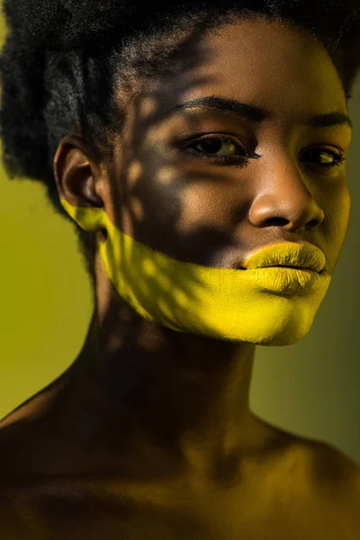 Beautiful african american woman with body art on yellow — Stock Photo