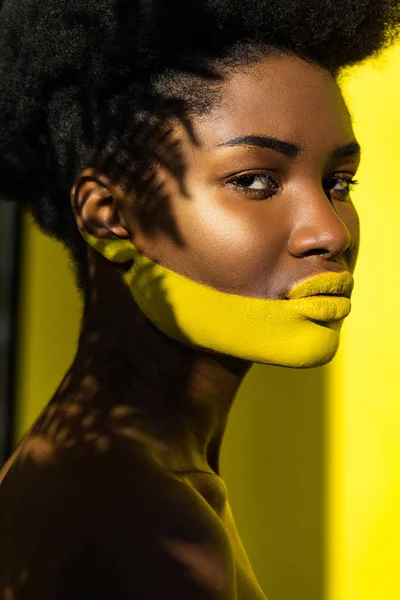 Beautiful african american woman with body art on yellow — Stock Photo