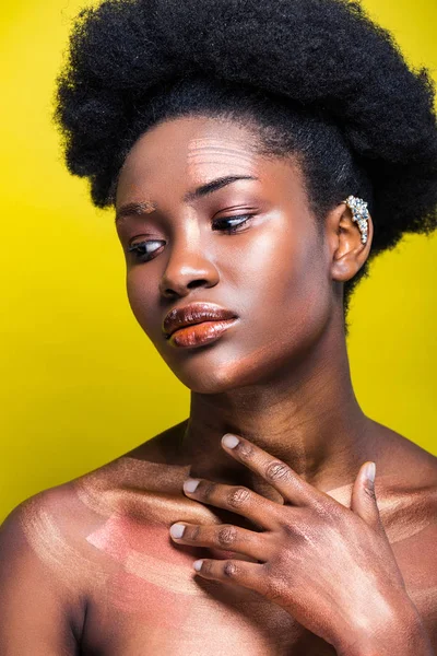 Mulher americana africana pensiva com manguito de orelha isolado no amarelo — Fotografia de Stock