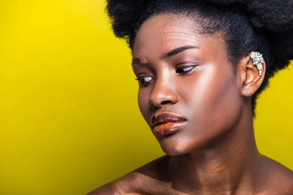 Mujer afroamericana atractiva pensativa con manguito en amarillo - foto de stock