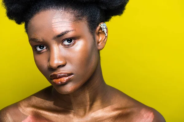 Mulher americana africana pensiva com manguito de orelha isolado no amarelo — Fotografia de Stock