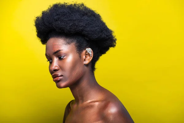 Pensive attractive african american woman with ear cuff on yellow — Stock Photo