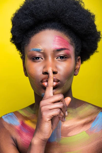 African american woman with bright makeup showing silent gesture isolated on yellow — Stock Photo