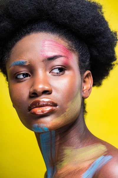 Menina americana africana sonhadora com arte corporal olhando para longe isolado no amarelo — Fotografia de Stock