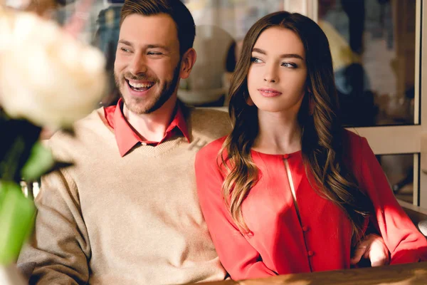 Glücklicher bärtiger Mann sitzt neben attraktivem Mädchen im Café — Stock Photo