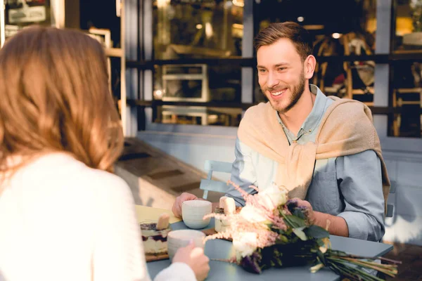 Happy man smiling while looking at young woman in cafe — Stock Photo