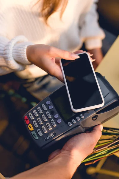 Ausgeschnittene Ansicht einer Frau, die im Café mit dem Smartphone bezahlt — Stockfoto