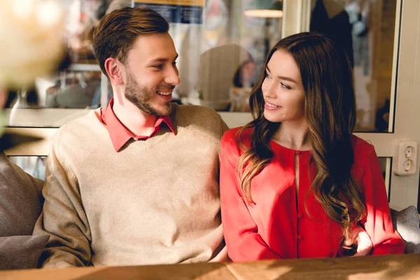 Homem feliz e jovem mulher olhando um para o outro no café — Stock Photo