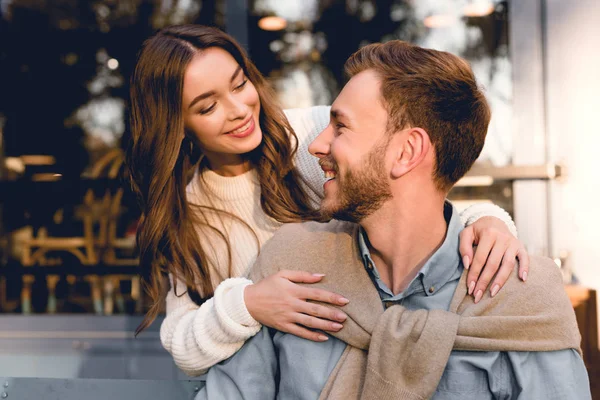 Alegre chica abrazando y mirando guapo barbudo novio - foto de stock