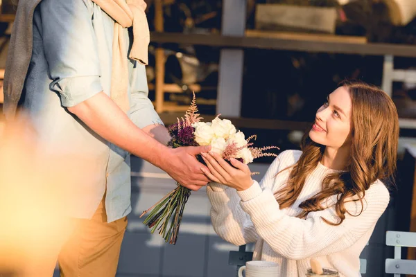 Обрізаний вид хлопця, що дарує букет квітів веселій дівчині — стокове фото