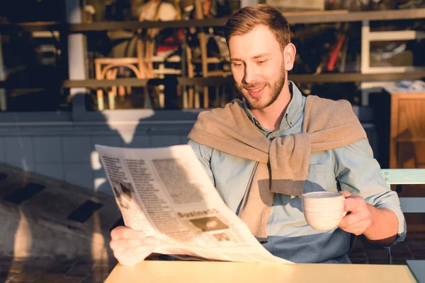 Homem feliz lendo jornal de negócios e segurando xícara de café — Fotografia de Stock