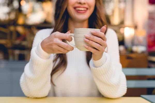 Vista ritagliata di allegra ragazza in possesso di tazza con caffè in caffè — Foto stock