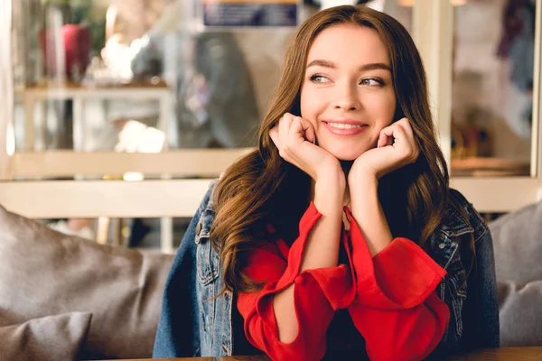 Atractiva y alegre joven mujer sonriendo en la cafetería - foto de stock