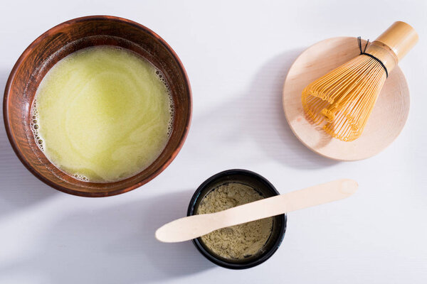 top view of arranged wooden cutlery and whisk for tea ceremony on white tabletop