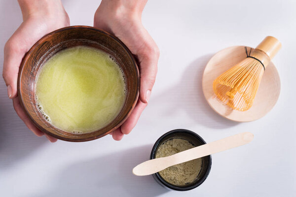 cropped shot of woman holding wooden bowl in hands in morning at home