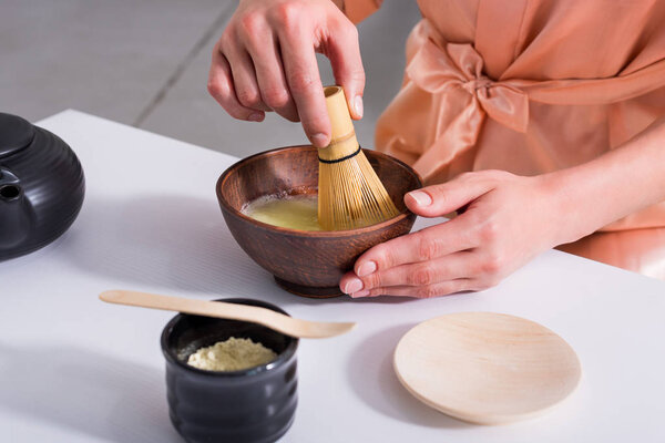 partial view of woman having tea ceremony in morning at home