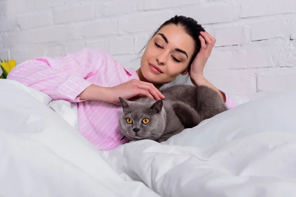 Retrato Mulher Sorridente Pijama Acariciando Gato Bretanha Shorthair Enquanto Descansa — Fotografia de Stock