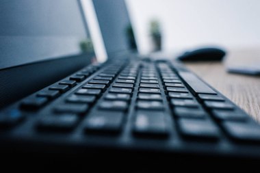 bilgisayar klavye bilgisayar fare ve laptop ile masada bakış bulanık arka plan üzerinde kapatın 