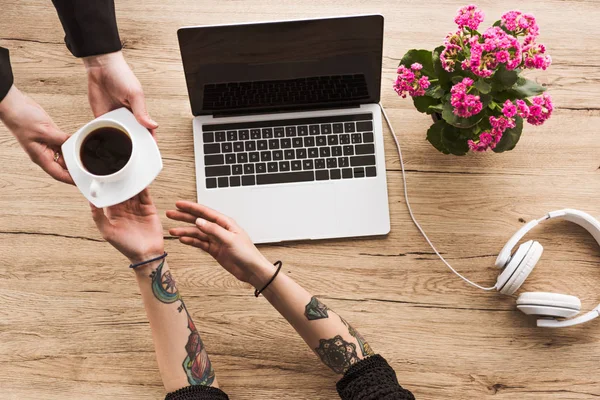 Cropped Shot Man Giving Coffee Woman Table Headphones Flowers — Free Stock Photo