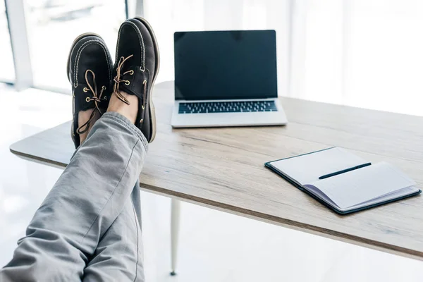 Teilansicht Der Männerbeine Auf Dem Tisch Mit Lehrbuch Und Laptop — Stockfoto