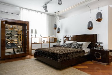 interior of modern light bedroom with lamps, shelves and brown bedsheets clipart