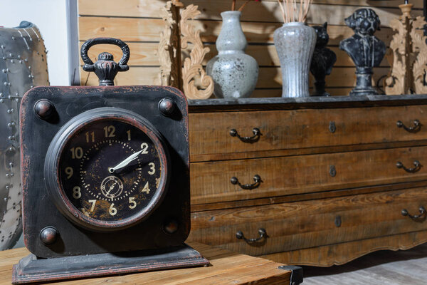old vintage clock on wooden table in modern retro styled living room