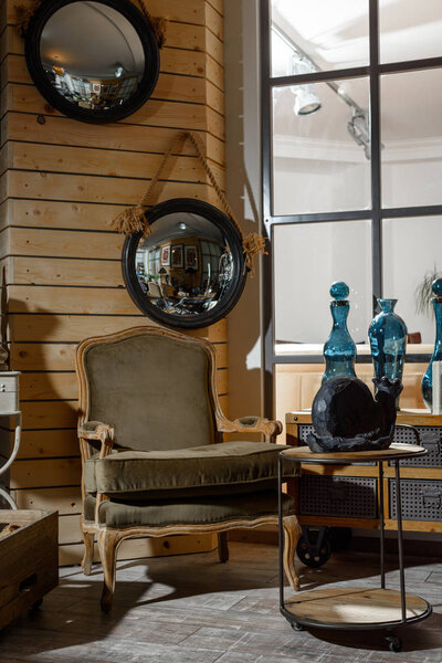 интерьер современной гостиной в стиле ретро с креслом и декоративной улиткой на столе
