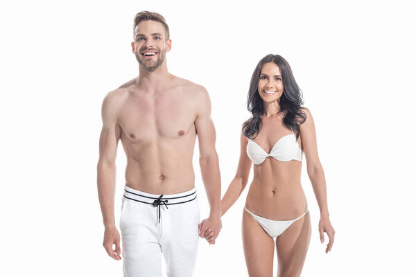 beautiful cheerful couple in swimwear holding hands, isolated on white