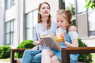 suyu içme ve bankta birlikte sokakta istirahat ederken annesi tarafından kitap okuma çocuk