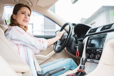side view of emotional woman honking horn while driving car clipart