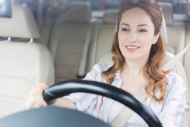 portrait of smiling woman driving car alone clipart