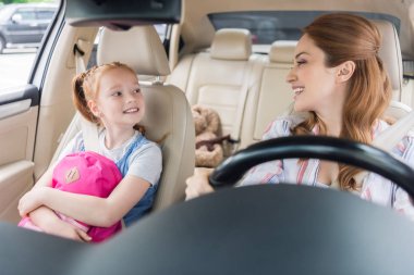 kızı yolcu koltuğu ile anne sürüş araba gülümseyen portresi