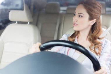 portrait of pensive woman looking away while driving car clipart