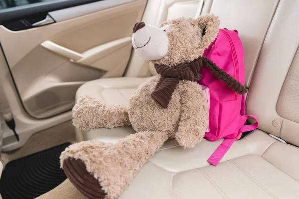 車のシートにピンクのバックパックでテディベアのビューをクローズ アップ — ストック写真