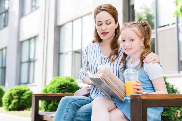 Niño Con Libro Lectura Jugo Con Madre Cerca Mientras Descansan —  Fotos de Stock