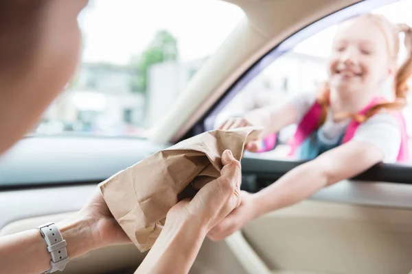 Bir Anne Kağıt Paket Gıda Ile Kızı Vererek Arabada Kısmi — Stok fotoğraf