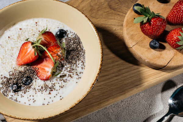 Healthy breakfast with chia seeds bowl and berries on wooden table