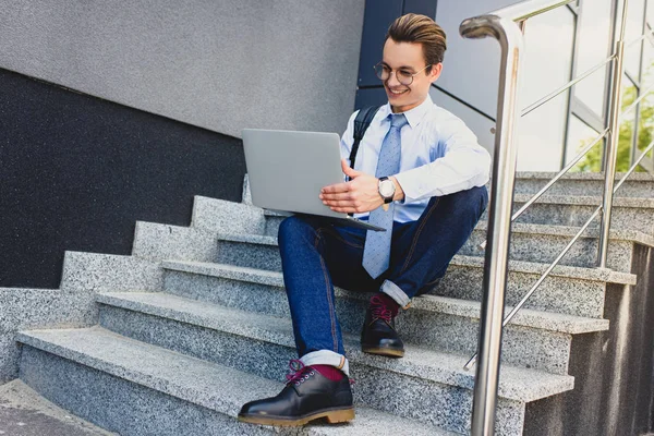 Lage Hoekmening Van Lachende Jongeman Brillen Zittend Trap Het Gebruik — Gratis stockfoto