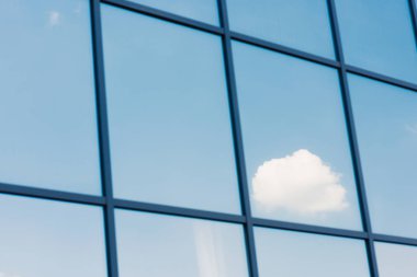 Sky and clouds reflection in the windows of modern office building clipart