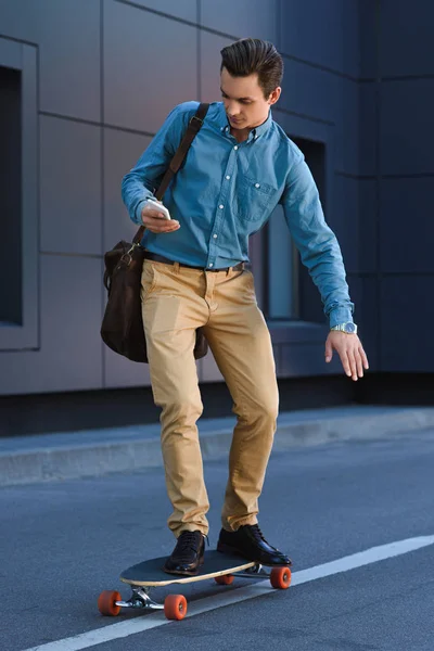 Joven Guapo Usando Teléfono Inteligente Monopatín Calle — Foto de stock gratuita