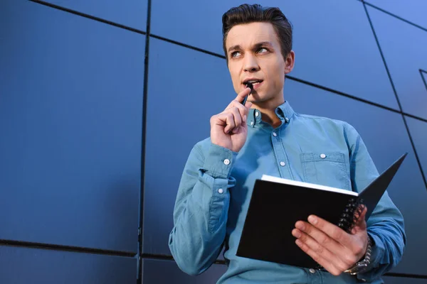 Low Angle View Pensive Young Man Holding Notepad Looking Away — Stock Photo, Image