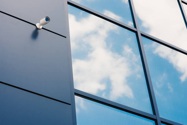 Glass facade of modern office building with security camera