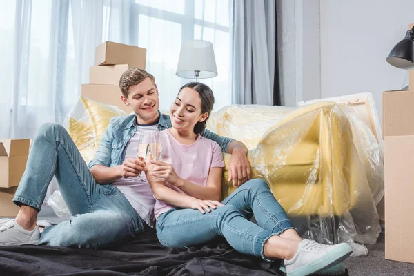 Bonito Jovem Casal Clinking Copos Champanhe Enquanto Sentado Chão Nova — Fotografia de Stock