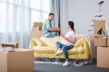 Yeni evine taşıdıktan sonra şampanya içmek Interracial genç çift
