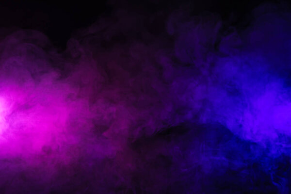 розовый и фиолетовый дым на абстрактном черном фоне
