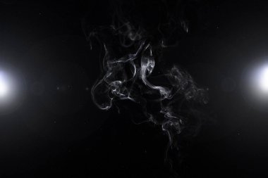 white smoke and two glowing lights on abstract black background clipart